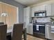 This kitchen provides stainless steel appliances, a tile backsplash, an adjacent dining area, and tiled flooring at 4912 Altura St, Denver, CO 80239