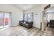 Inviting living room features tile flooring, a comfortable sofa, and an open view to the dining area at 4912 Altura St, Denver, CO 80239