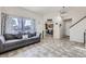 Inviting living room features tile flooring, a comfortable sofa, and an open view to the kitchen at 4912 Altura St, Denver, CO 80239