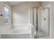 Bright bathroom with a shower and a tub with tile surround at 6735 W 97Th Cir, Westminster, CO 80021