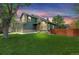View of the home showing the manicured lawn and mature trees surrounding the property at 6735 W 97Th Cir, Westminster, CO 80021
