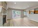 Open-concept living room featuring a fireplace, new flooring, and sliding glass doors to outdoor space at 6735 W 97Th Cir, Westminster, CO 80021