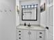 Bright white bathroom with vanity, a sink, and storage; stylish mirror with lighting above at 12978 Dexter St, Thornton, CO 80241