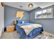 Comfortable bedroom featuring a bed with a blue comforter and a unique lightning bolt wall design at 12978 Dexter St, Thornton, CO 80241