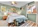 Serene bedroom with green walls, a plush bed with decorative pillows, and lots of natural light at 12978 Dexter St, Thornton, CO 80241