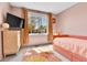 Pink bedroom featuring lots of natural light and retro accents, including a shag rug and pink bed at 12978 Dexter St, Thornton, CO 80241