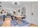 Open dining and living area features hardwood floors, a statement mirror, and modern light fixture at 12978 Dexter St, Thornton, CO 80241
