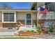 Charming entrance with decorative brick, an American flag, and lovely landscaping creating a welcoming curb appeal at 12978 Dexter St, Thornton, CO 80241