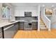 Updated kitchen with sleek countertops, stainless steel appliances, and stylish backsplash complemented by a staircase at 12978 Dexter St, Thornton, CO 80241