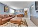 Spacious living room featuring comfortable leather furniture, stairs, and stylish decor at 12978 Dexter St, Thornton, CO 80241