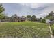 Spacious backyard showcasing the home's brick exterior, lush lawn, privacy fence, and mature trees for serene outdoor living at 10633 E 6Th Pl, Aurora, CO 80010