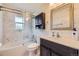 Modern bathroom with marble tile, dark wood vanity and glass-enclosed shower at 10633 E 6Th Pl, Aurora, CO 80010
