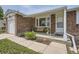 Close-up of the home's entrance featuring a cozy front porch with a bench and landscaping at 10633 E 6Th Pl, Aurora, CO 80010