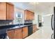 Modern kitchen with wood cabinets, black countertops, and stainless steel appliances at 10633 E 6Th Pl, Aurora, CO 80010