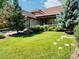 Inviting front yard with healthy lawn, rock feature, and colorful daisylike flowers at 10553 Adams St, Northglenn, CO 80233