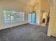 Open-concept living room with a vaulted ceiling, large window, and carpet at 10553 Adams St, Northglenn, CO 80233