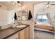 Bathroom with a vanity and view of the bedroom with a sliding door to a patio at 15475 Andrews Dr # 318, Denver, CO 80239