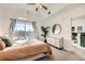 Bright bedroom with a sliding glass door to a patio, a dresser, neutral decor, and a ceiling fan at 15475 Andrews Dr # 318, Denver, CO 80239