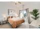 Bright bedroom with a sliding glass door to a patio, bedside tables and lamps, and neutral decor at 15475 Andrews Dr # 318, Denver, CO 80239