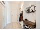 Bright foyer with tile flooring, coat closet, and decorative shelf at 15475 Andrews Dr # 318, Denver, CO 80239