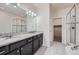 Modern bathroom with double vanity, granite countertops, and a glass-enclosed shower at 6634 S Patsburg St, Aurora, CO 80016