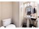 A tidy half-bathroom with pedestal sink, round mirror, and neutral wall paint at 9186 Viaggio Way, Highlands Ranch, CO 80126