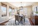 A dining room with natural lighting, wooden table, modern light fixture and access to outdoor patio at 9186 Viaggio Way, Highlands Ranch, CO 80126