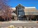 Front entrance of a modern building with large glass windows, a peaked roof, and meticulously maintained landscaping at 9186 Viaggio Way, Highlands Ranch, CO 80126