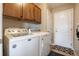 A laundry room with washer, dryer, cabinets, and a door to the outside at 9186 Viaggio Way, Highlands Ranch, CO 80126