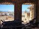 Covered patio with brick pillars and built in outdoor kitchen overlooking the mountains at 9186 Viaggio Way, Highlands Ranch, CO 80126