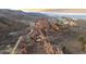 Stunning aerial view of the home nestled among red rock formations and rugged mountain landscape at 3755 N Rampart Range Rd, Littleton, CO 80125