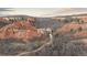 Expansive aerial view of a beautiful home nestled among massive rock formations and lush greenery at 3755 N Rampart Range Rd, Littleton, CO 80125
