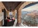 Covered balcony with stone arches, wrought iron railings, and comfortable seating overlooking natural surroundings at 3755 N Rampart Range Rd, Littleton, CO 80125