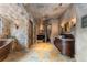 Luxury bathroom features stone accent walls, double vanities with vessel sinks, and copper soaking tub at 3755 N Rampart Range Rd, Littleton, CO 80125