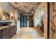 Luxury bathroom features stone accent wall, vanity with vessel sink, and copper soaking tub at 3755 N Rampart Range Rd, Littleton, CO 80125