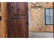 Rustic wooden entryway door leading to a room with stone walls and decorative lighting at 3755 N Rampart Range Rd, Littleton, CO 80125