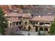 Grand stone residence showcasing a tile roof, arched entry, and meticulously designed facade at 3755 N Rampart Range Rd, Littleton, CO 80125
