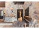 Stone foyer featuring brick floors, wood accents, and a rustic bench at 3755 N Rampart Range Rd, Littleton, CO 80125
