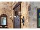Charming foyer with stone walls, sconce lighting, and a decorative wooden door and accents at 3755 N Rampart Range Rd, Littleton, CO 80125