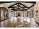 Spacious living room with stone accents, hardwood floors, and high ceilings, complemented by natural light and elegant lighting at 3755 N Rampart Range Rd, Littleton, CO 80125