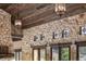 Elegant living room with stone walls, wooden ceilings, and stylish pendant lighting fixtures at 3755 N Rampart Range Rd, Littleton, CO 80125