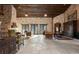 Expansive living room featuring stone walls, wood beams, and multiple seating areas with access to the outdoors at 3755 N Rampart Range Rd, Littleton, CO 80125