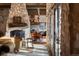 Inviting living room with a stone fireplace, chandelier, and access to the dining area at 3755 N Rampart Range Rd, Littleton, CO 80125