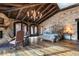 Bright main bedroom boasts hardwood floors, stone accent wall, wood beamed ceiling and fireplace at 3755 N Rampart Range Rd, Littleton, CO 80125