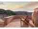 Relaxing outdoor patio with wooden chairs overlooking a beautiful mountain landscape at 3755 N Rampart Range Rd, Littleton, CO 80125