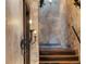 Unique staircase with stone walls, decorative sconces and wooden steps at 3755 N Rampart Range Rd, Littleton, CO 80125