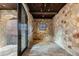 Stone walled sunroom with brick floor and glass door leading to an outdoor area, offering natural light at 3755 N Rampart Range Rd, Littleton, CO 80125