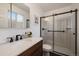 Modern bathroom featuring a wood vanity and sink, a glass-enclosed shower, and modern hardware at 11570 Depew Ct, Westminster, CO 80020