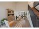 Bright living room with hardwood floors, a staircase, a large cabinet and an open dining room at 11570 Depew Ct, Westminster, CO 80020