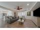 A modern living room with a ceiling fan, hardwood floors, a kitchen, and neutral tones at 11570 Depew Ct, Westminster, CO 80020